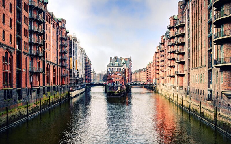 Canal Between Brick Buildings — Red