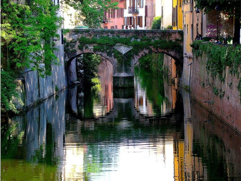 Canal with arched bridge in Italy