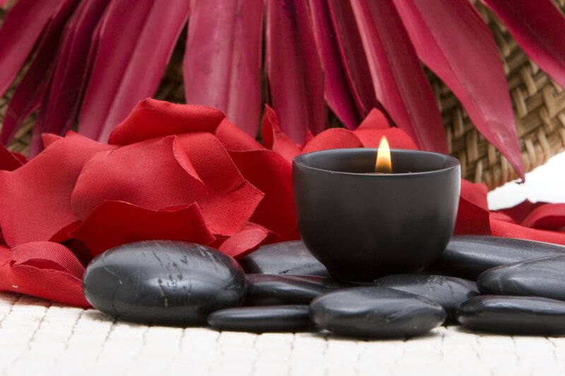 Candle with stones and red petals