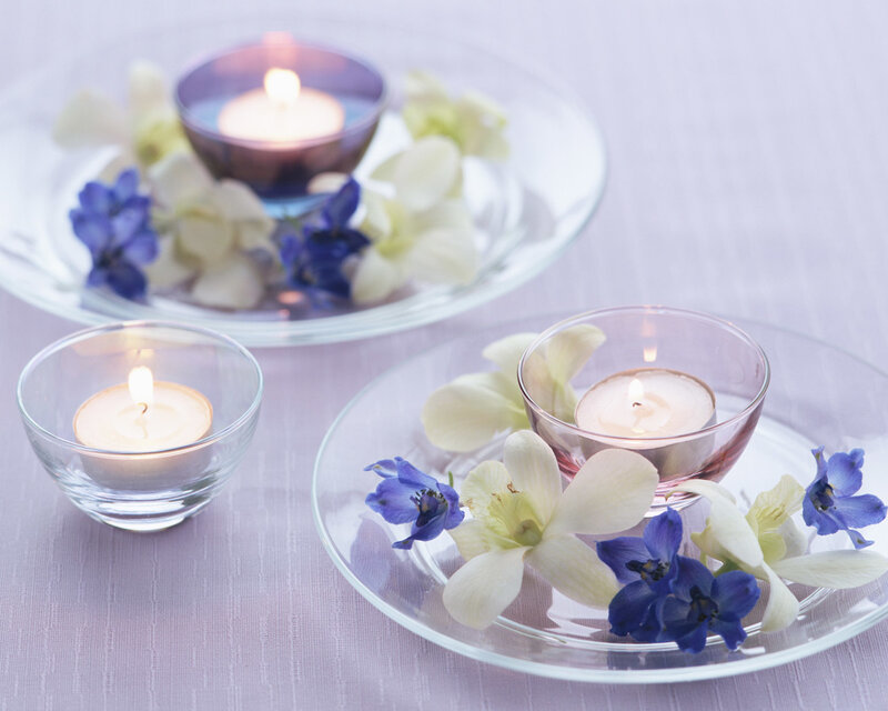 Candles and flowers on glass plates