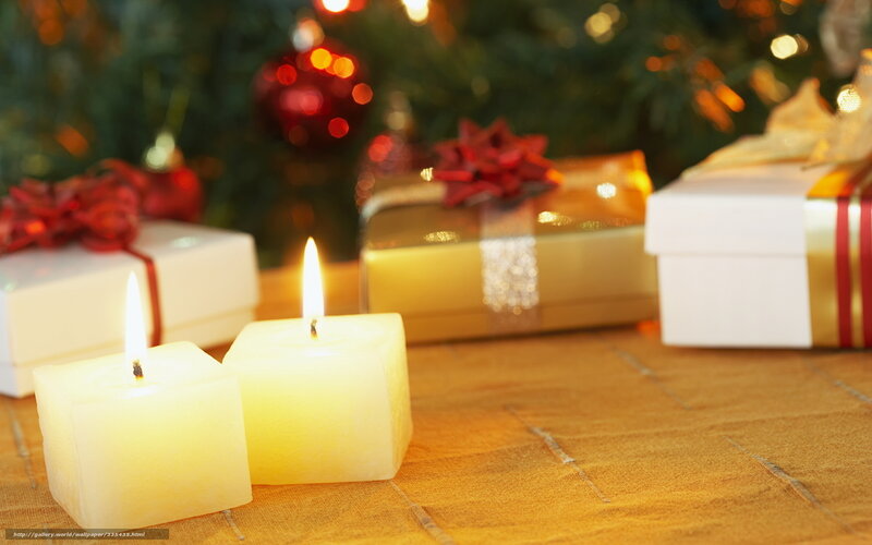 Candles and gifts by Christmas tree