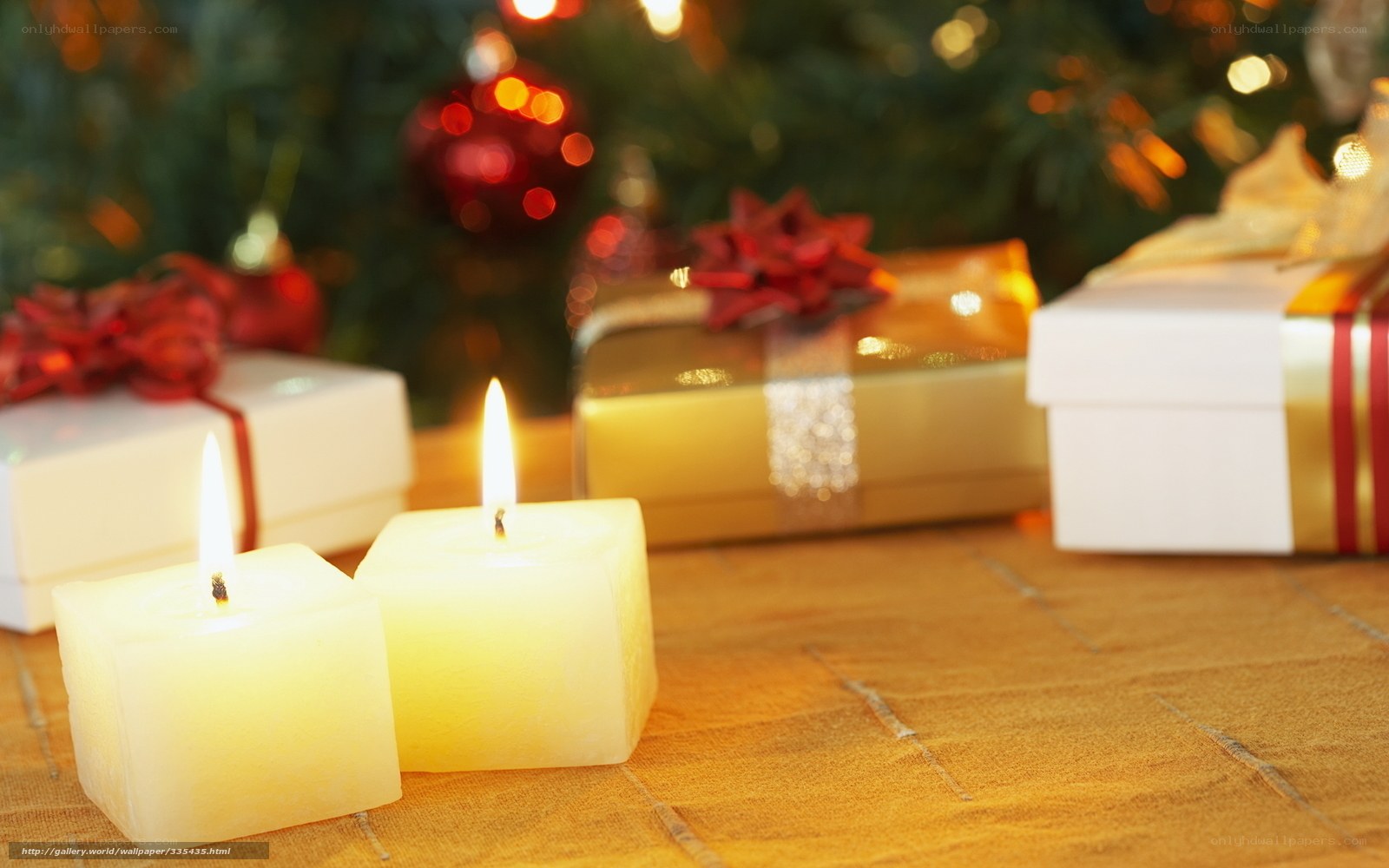 Candles and gifts by Christmas tree