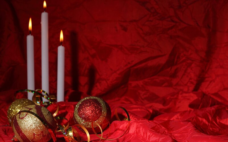 Candles and ornaments on red cloth