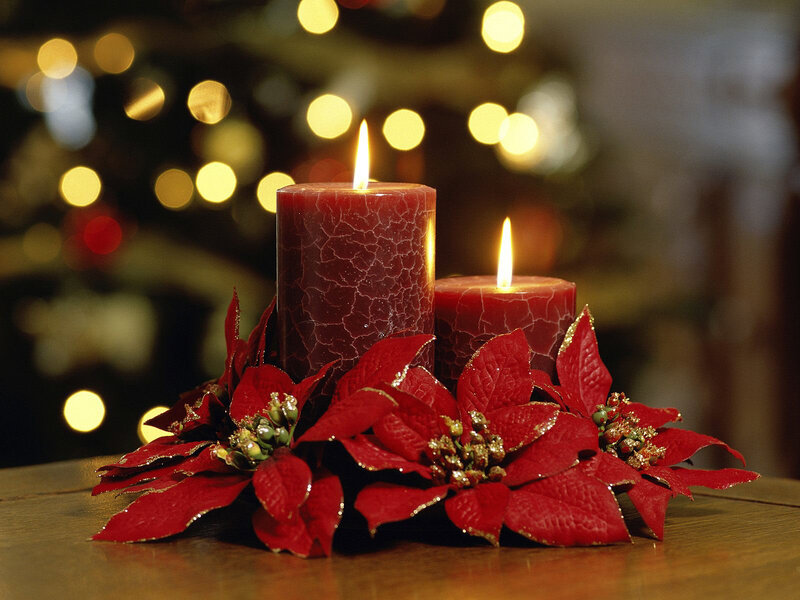 Candles and poinsettias on table