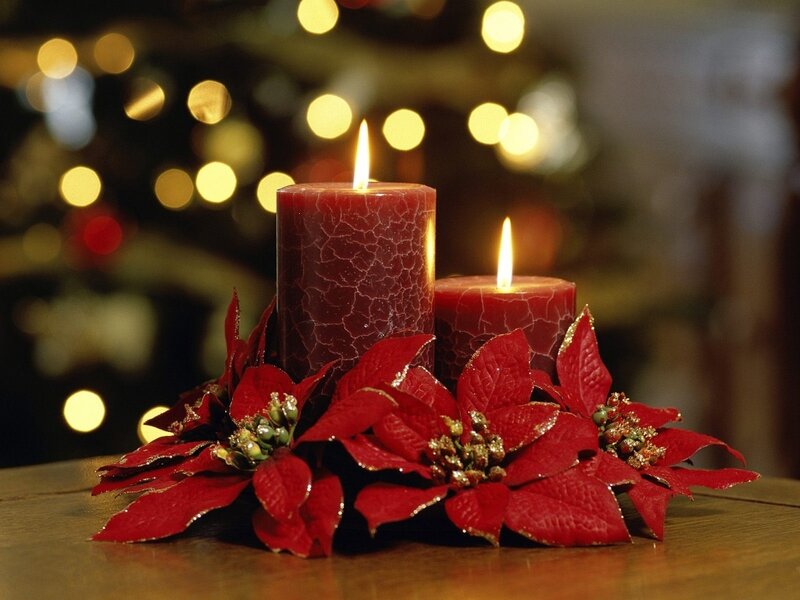 Candles and poinsettias on table