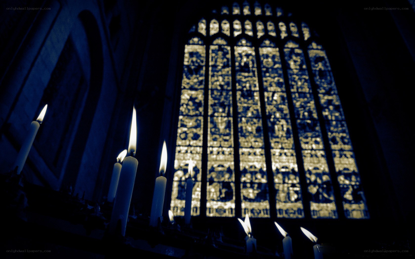 Candles before stained glass window