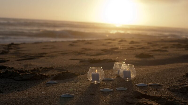 Candles on the beach at sunset