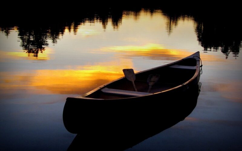 Canoe at sunset on calm lake