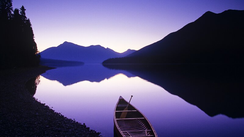 Canoe on a calm lake at dusk
