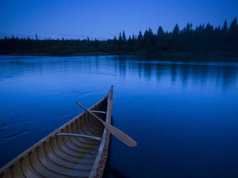 Canoe on a calm lake at dusk