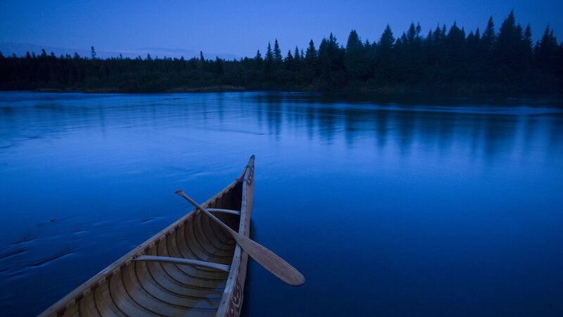Canoe on a calm lake at dusk