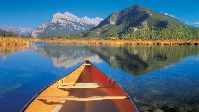 Canoe on a calm lake with mountains
