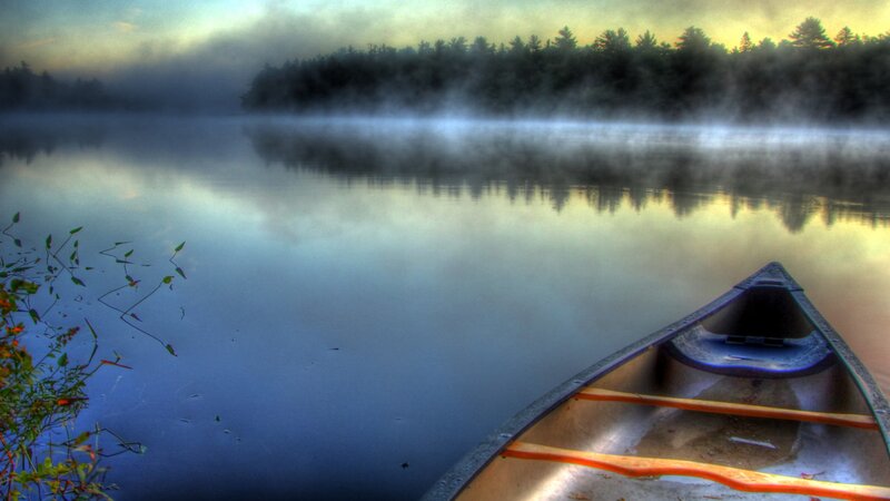 Canoe on a misty lake at dawn