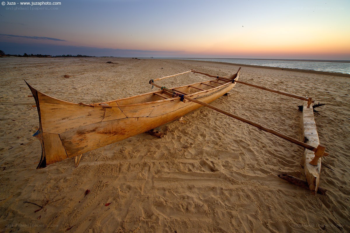 Canoe on a sandy beach at sunset