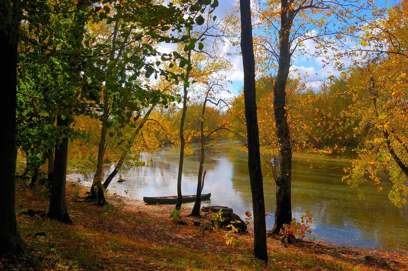 Canoe on Riverbank — Green, Serene, Autumn