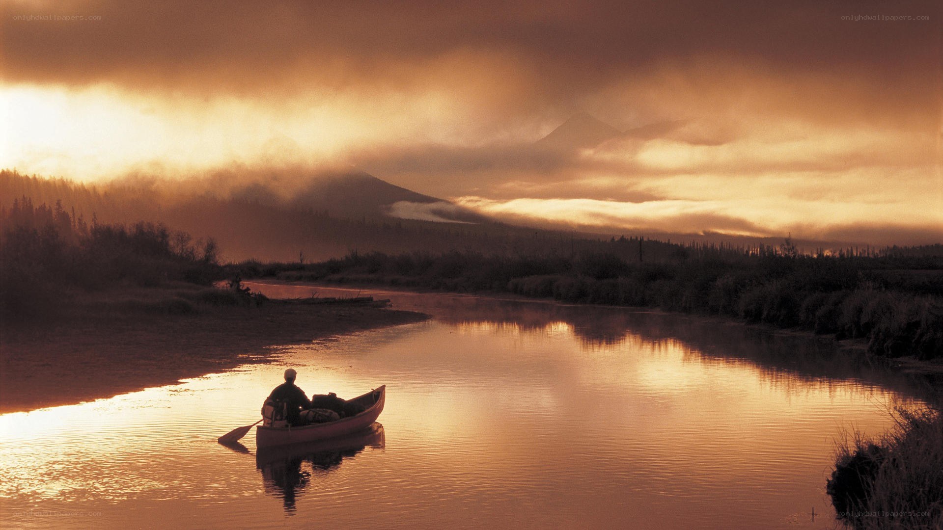 Canoeist on a river at sunset