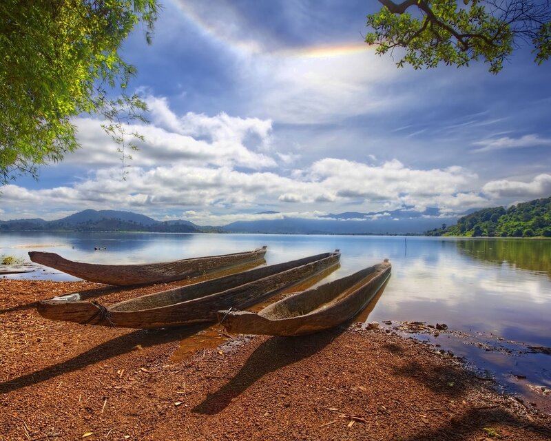 Canoes on a lakeshore with rainbow
