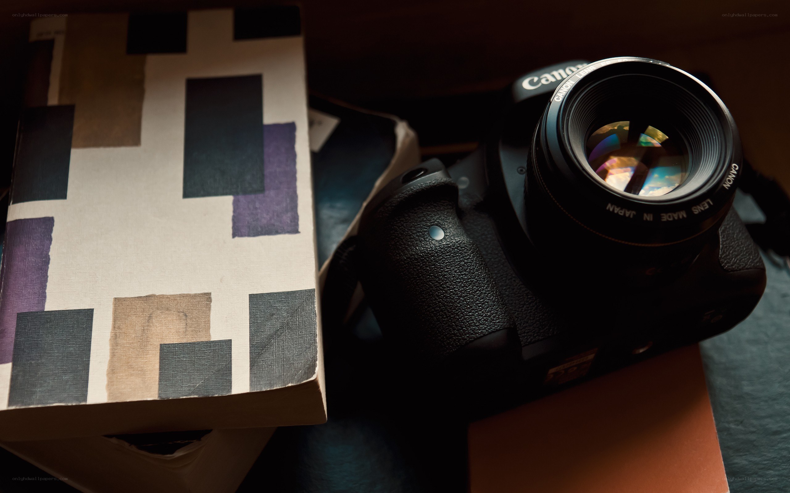 Canon camera and book on table