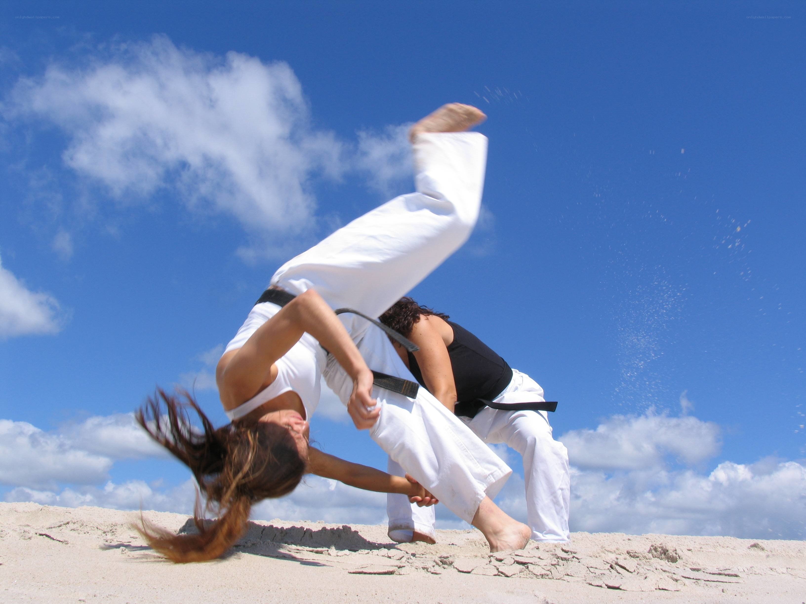 Capoeira practitioners on beach