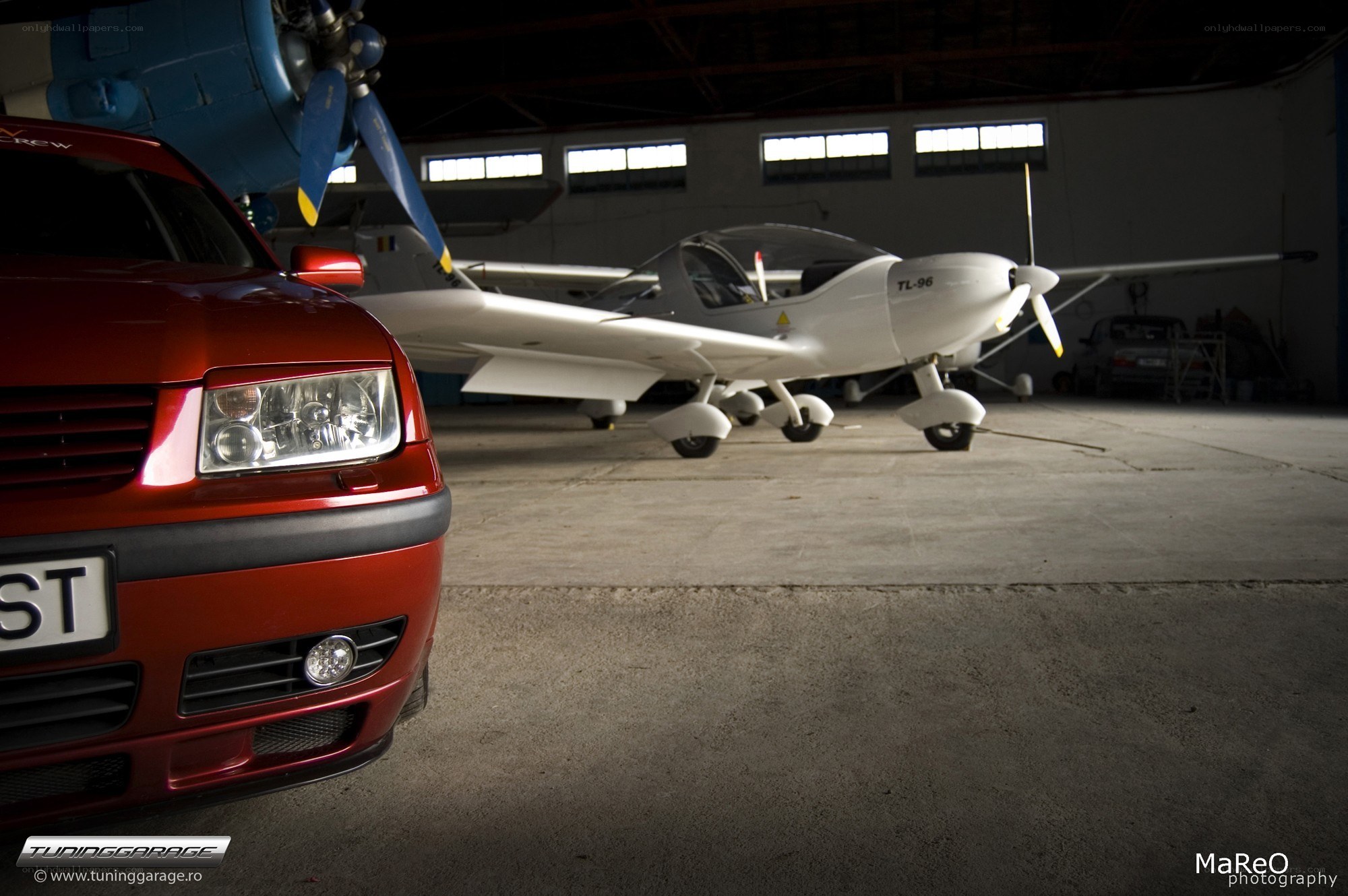 Car and airplane in hangar