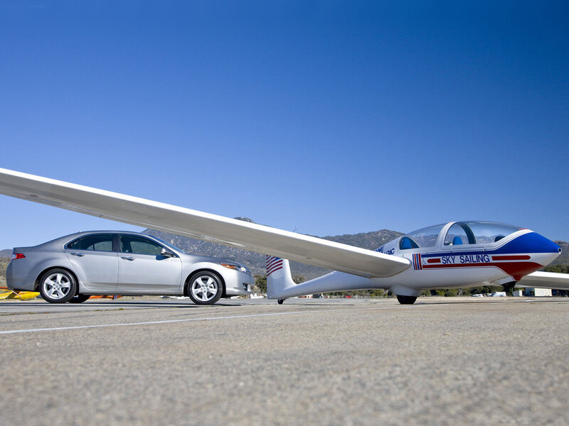 Car and glider on tarmac