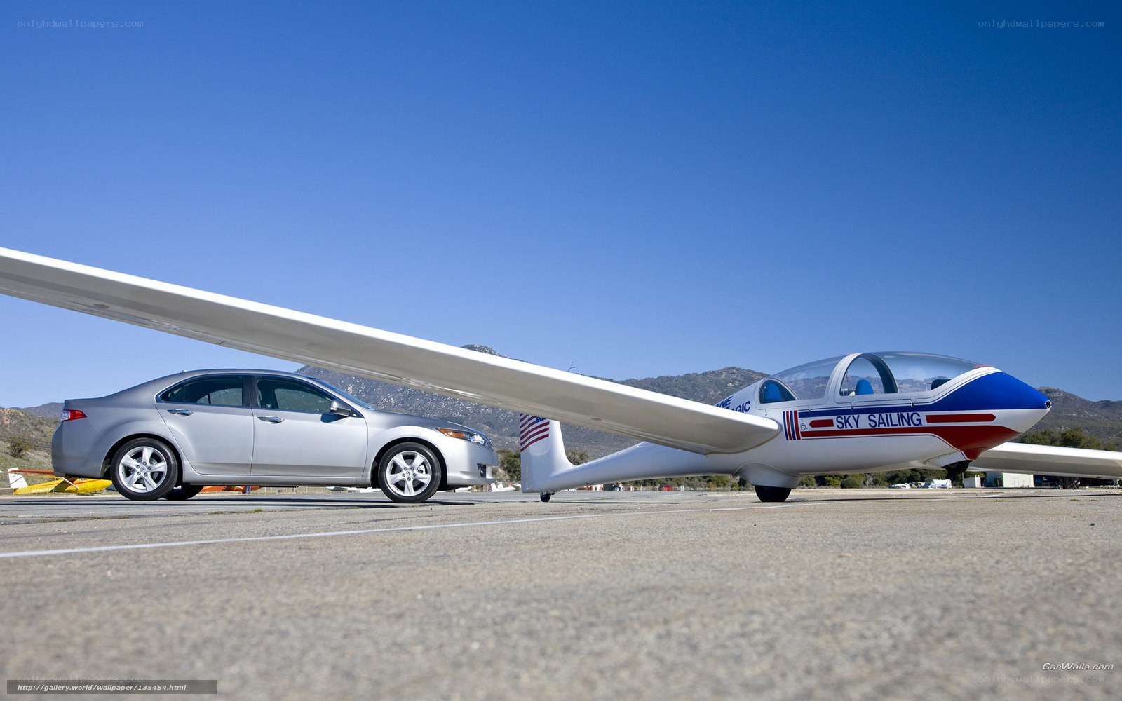 Car and glider on tarmac