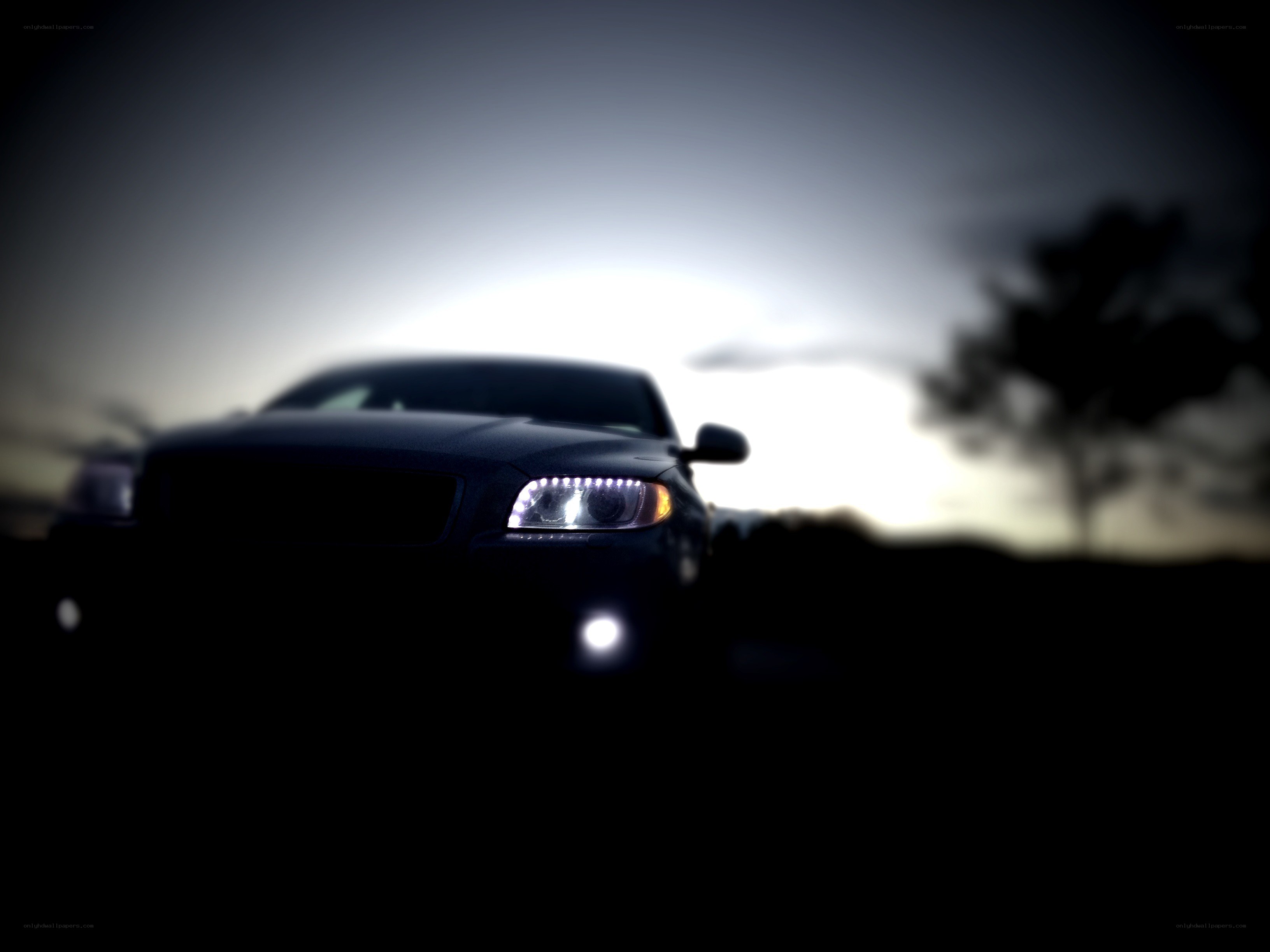 car at dusk with headlights on
