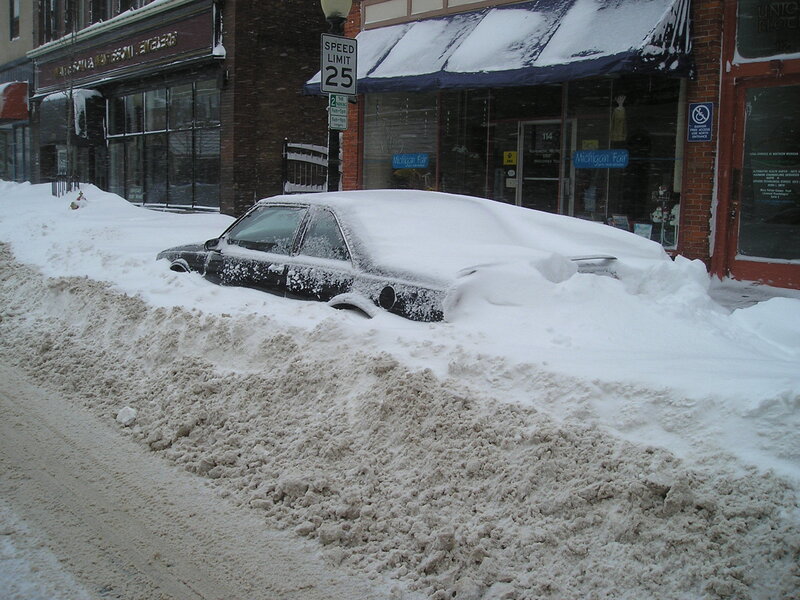 Car buried in snow on street