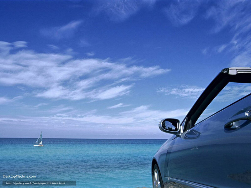 Car by the ocean with sailboat