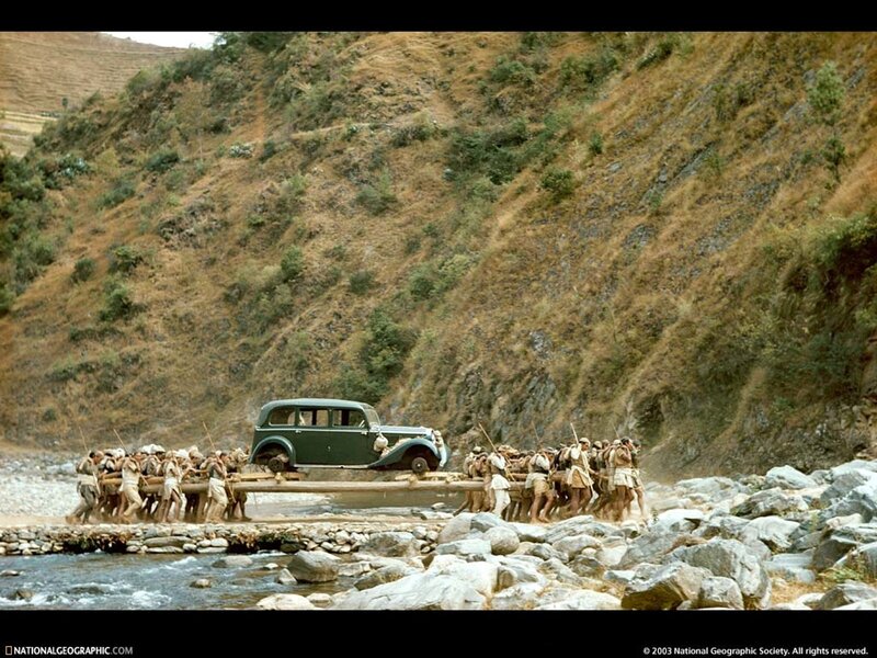Car carried across river by porters