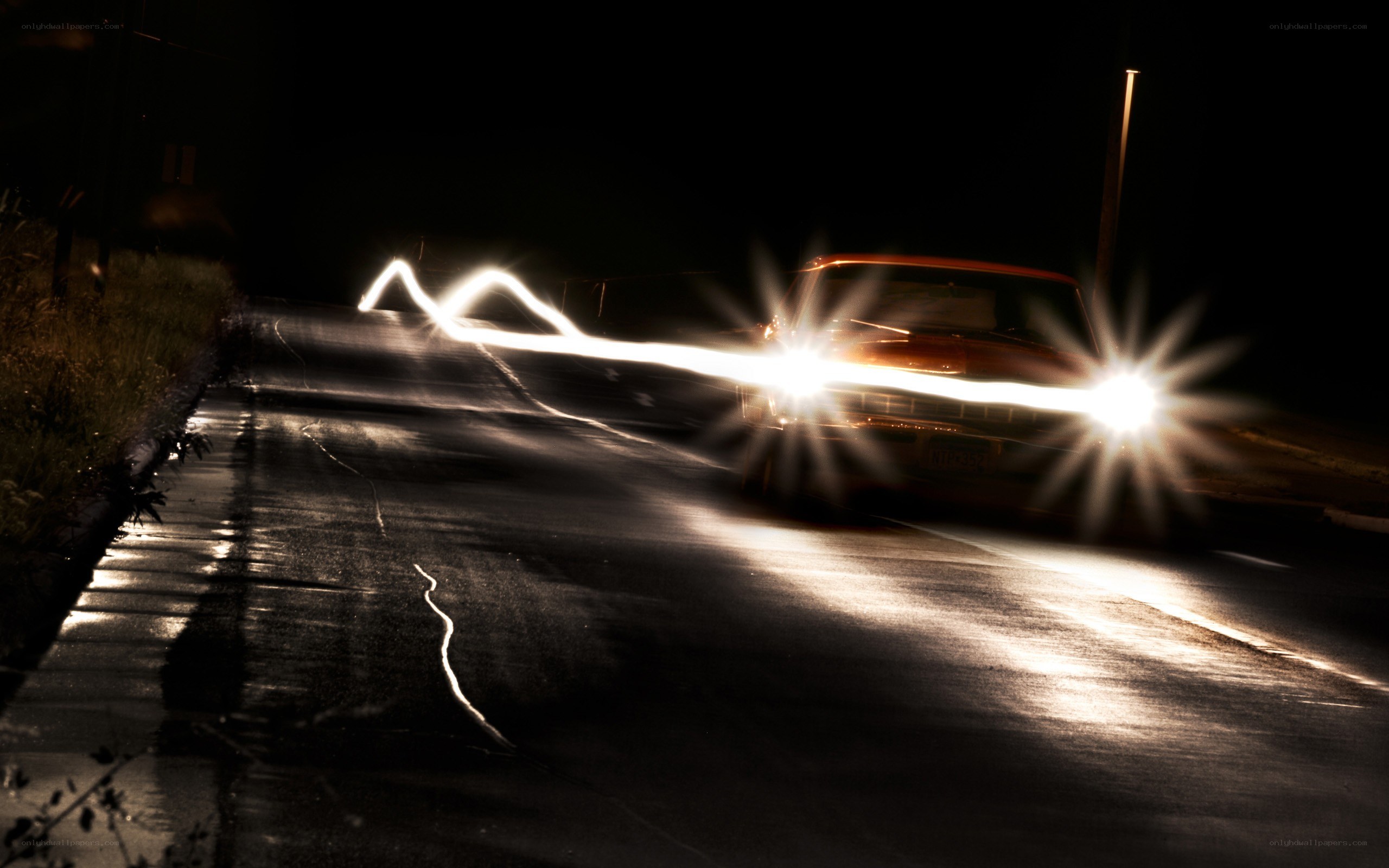 Car driving at night with light trails