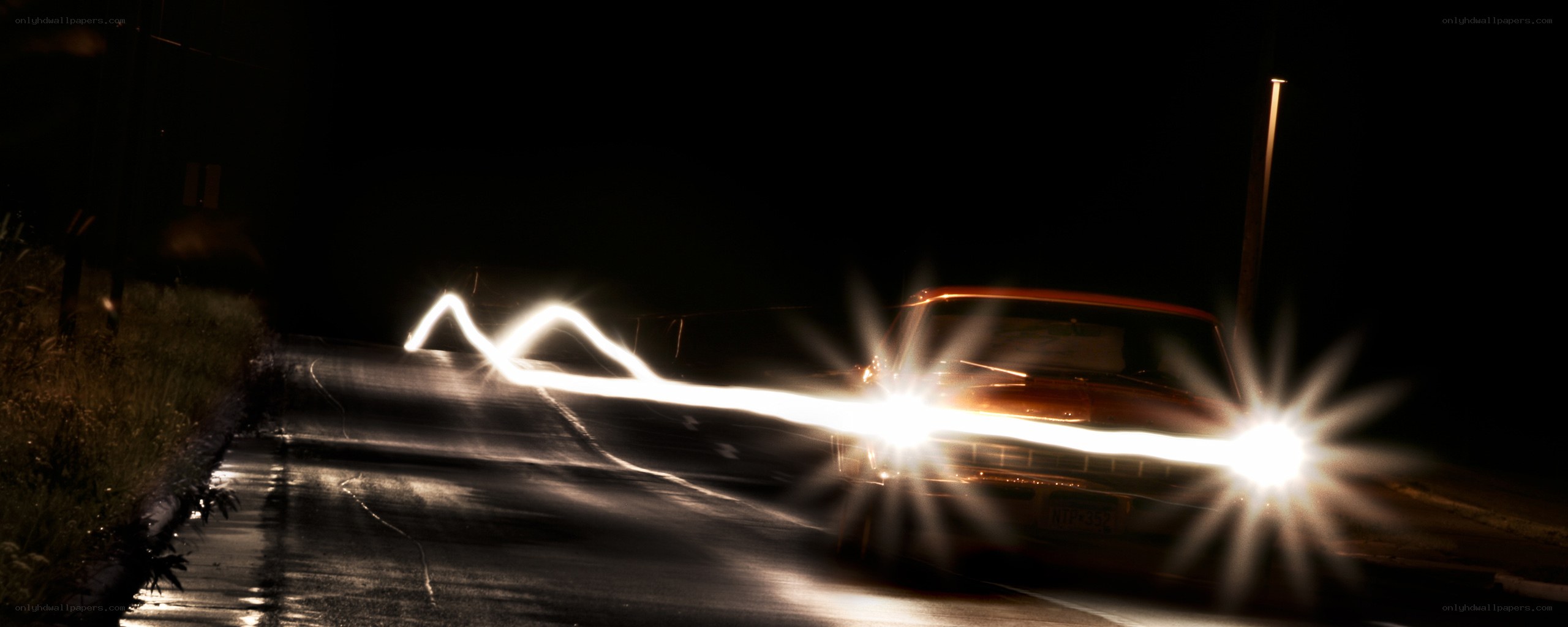 Car driving at night with light trails