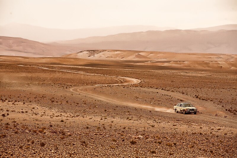 Car driving in desert landscape