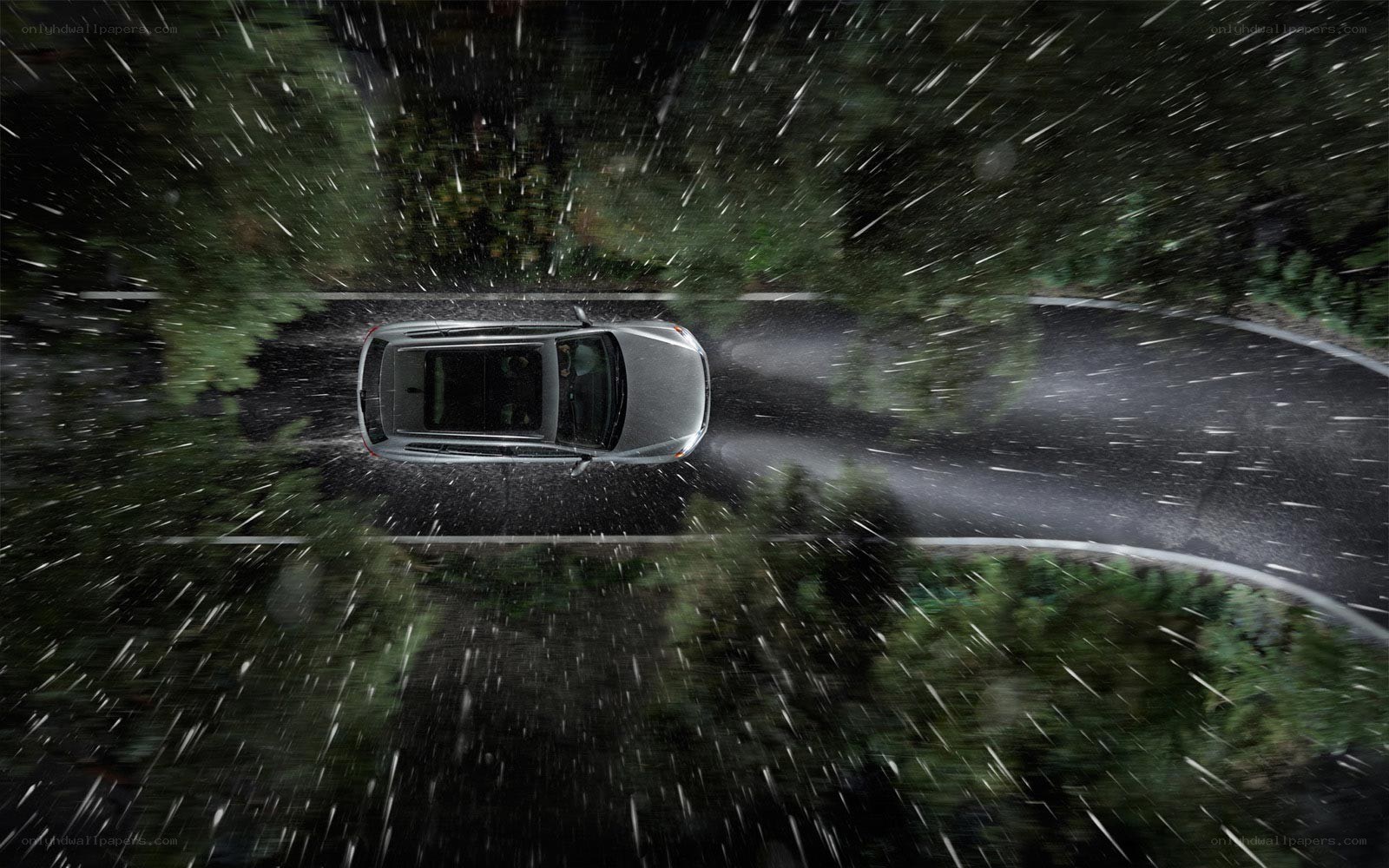 Car driving in rain at night