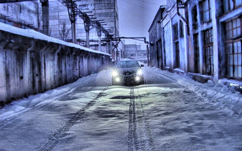 Car driving in snowy alley