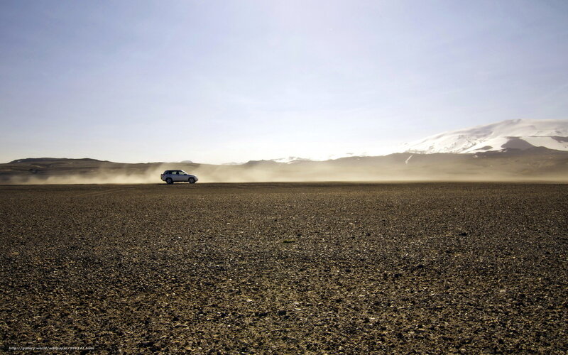 Car driving on a dusty plain