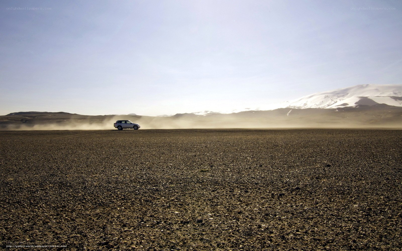Car driving on a dusty plain