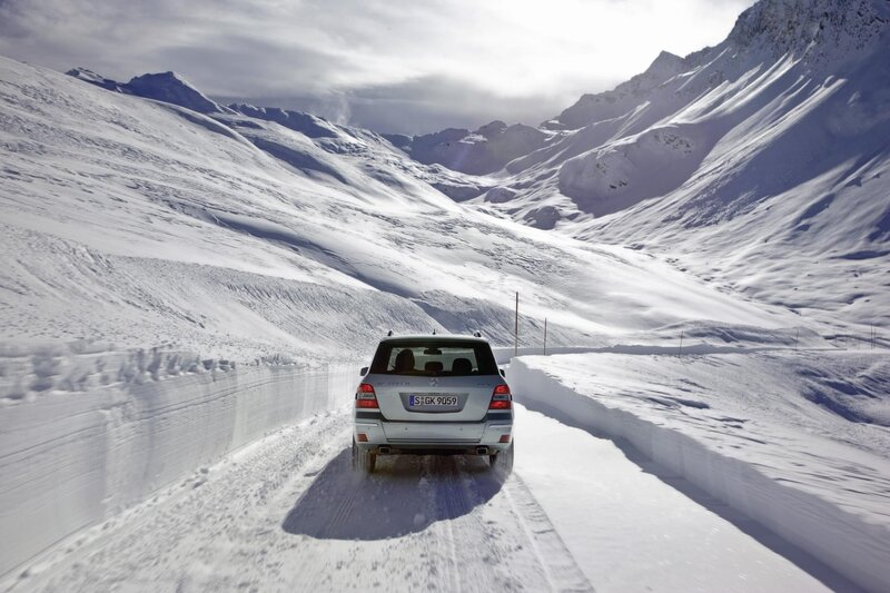 Car driving on snowy mountain road