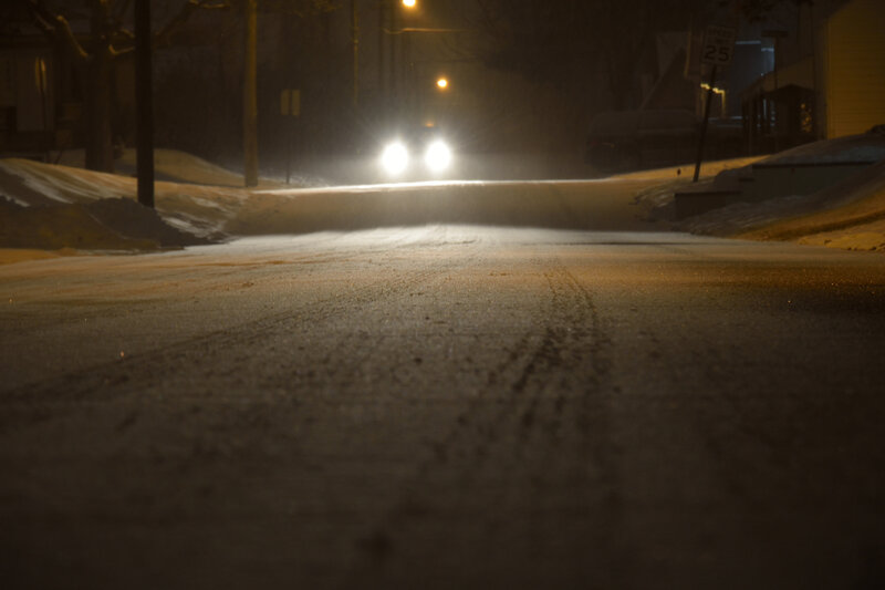 Car Headlights on Snowy Street