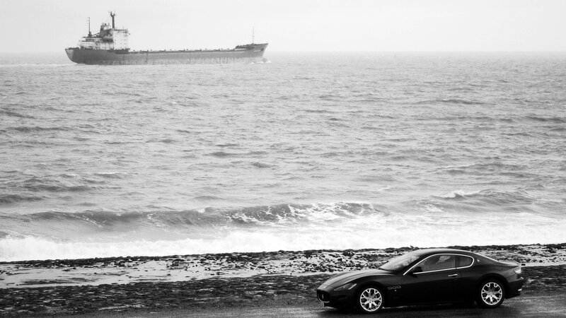 Car on a beach with ship
