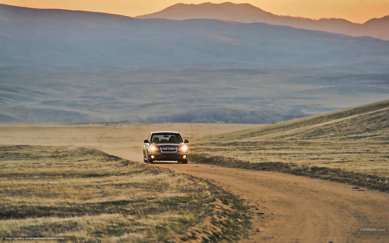 Car on a dirt road at sunset