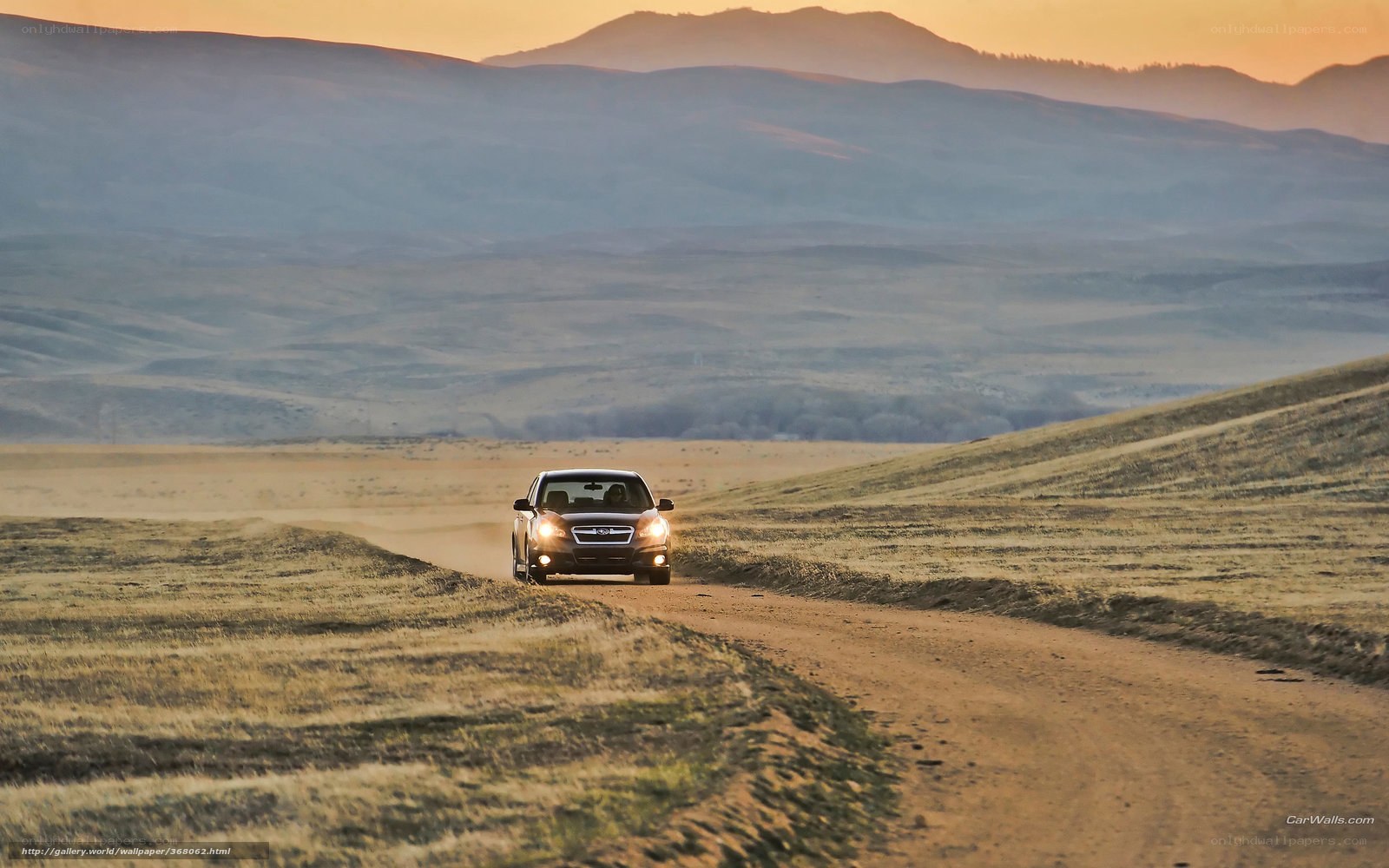 Car on a dirt road at sunset