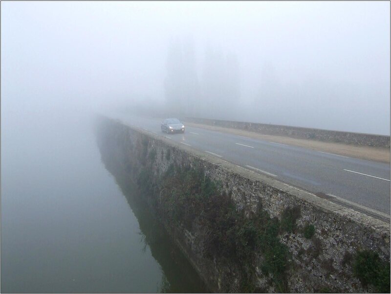 Car on a foggy bridge