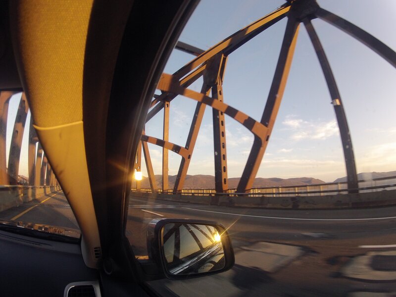 car on bridge at sunset