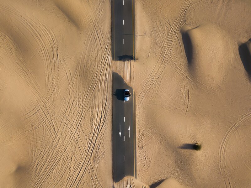 Car on Desert Road — Brown, Desolate