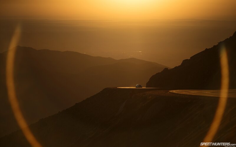 Car on mountain road at sunset