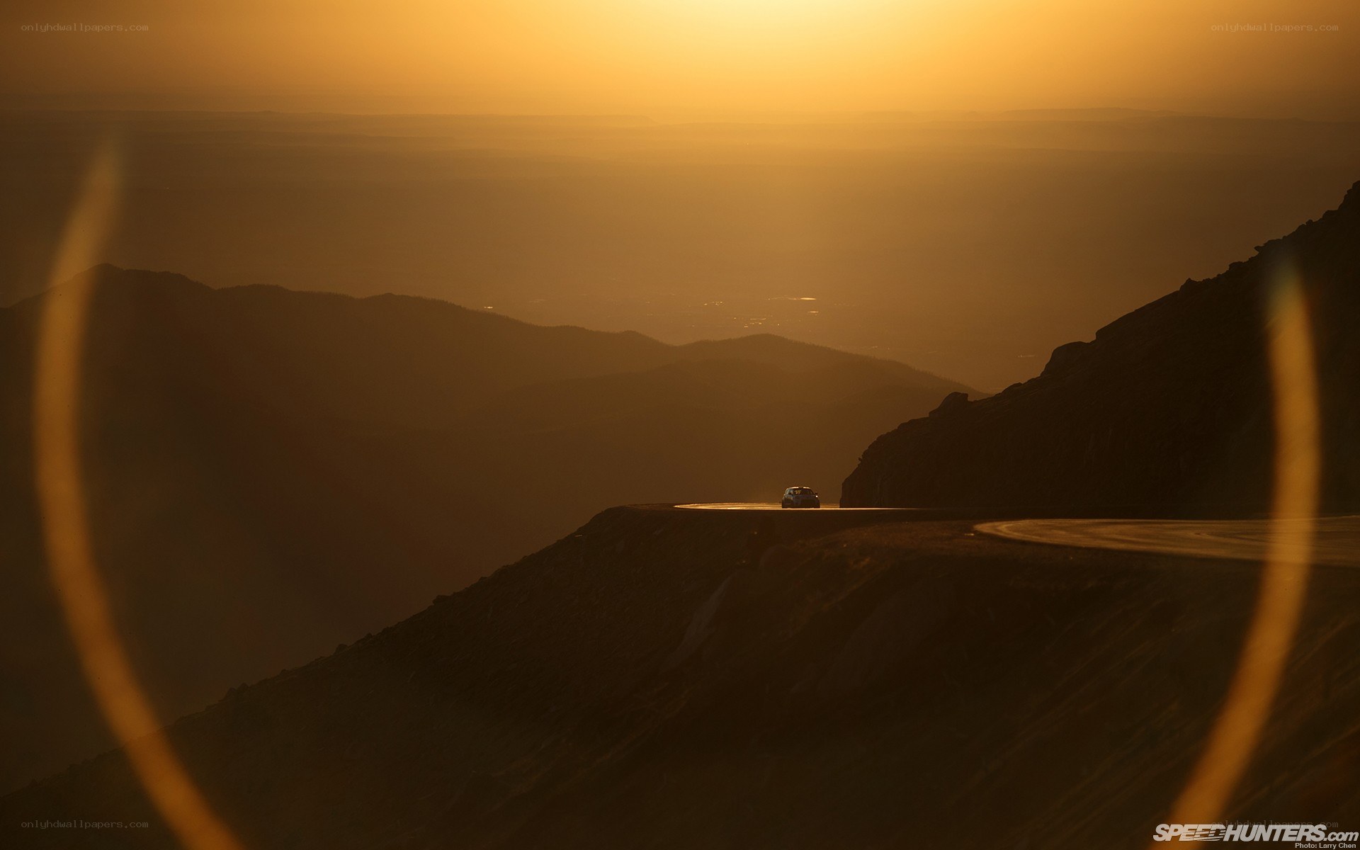 Car on mountain road at sunset