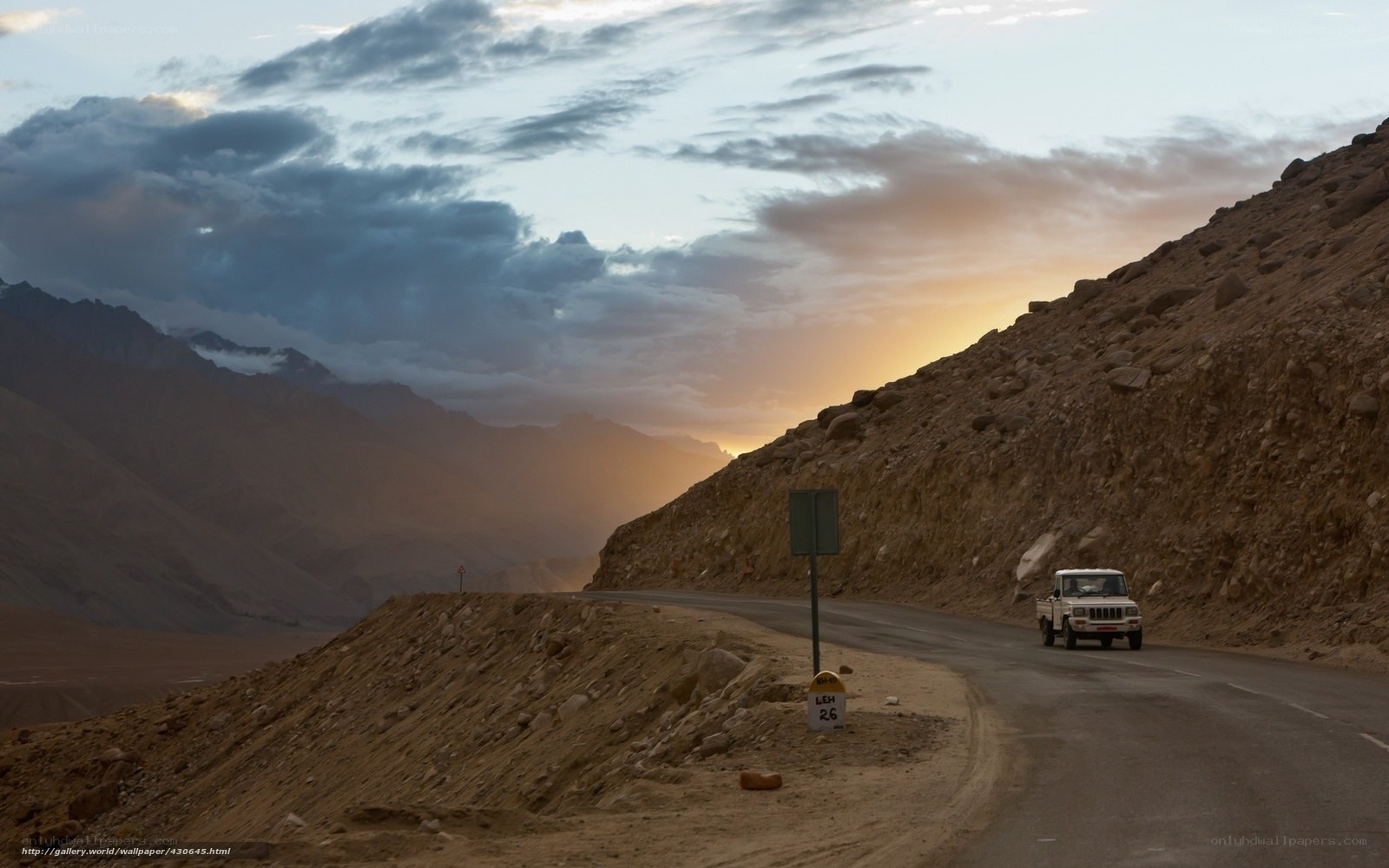 Car on mountain road at sunset