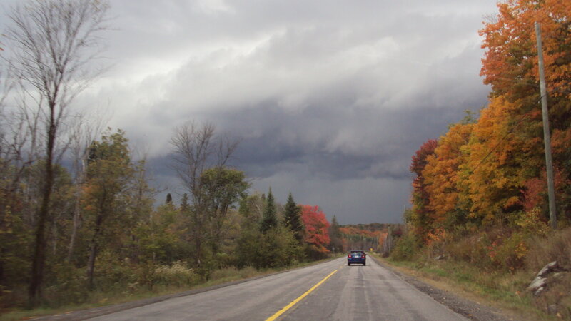 Car on road under stormy sky