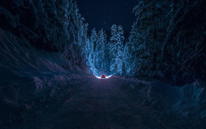 Car on snowy road at night